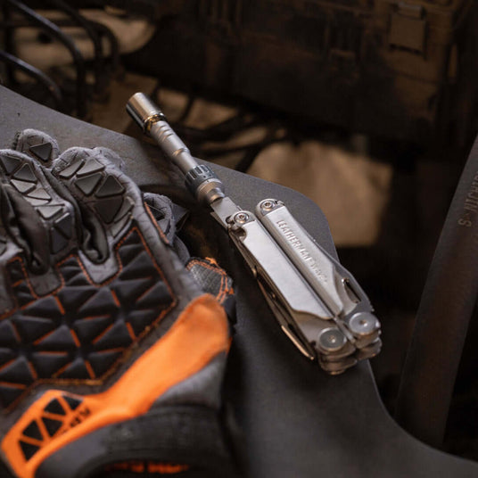 Translation missing: en.Stainless Steel Leatherman Wave® Plus multi-tool with ratchet driver beside protective gloves