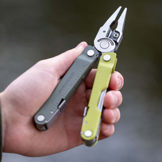 Translation missing: en.Person holding a Mossy Slate Leatherman Rebar multi-tool, perfect for outdoor activities and repairs