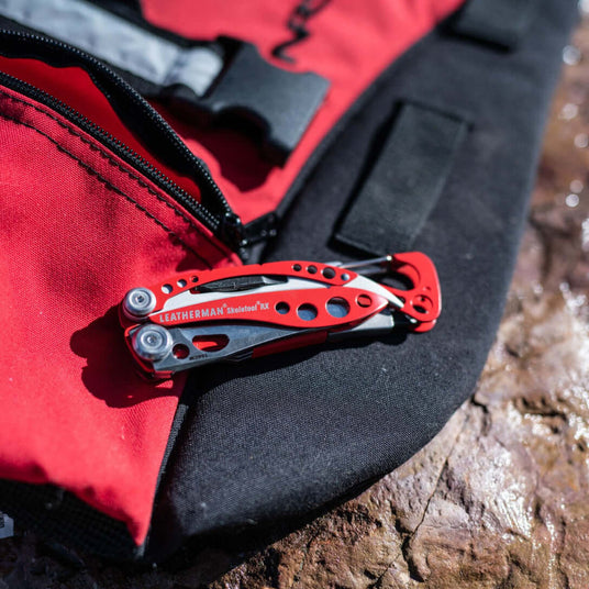 Translation missing: en.Close-up of a red Leatherman Skeletool® RX on a black and red bag, showcasing its versatility and design