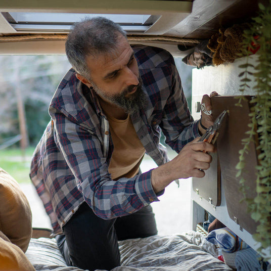Translation missing: en.Man using a Mesa Verde Leatherman Signal® tool inside a van for home improvement and repairs