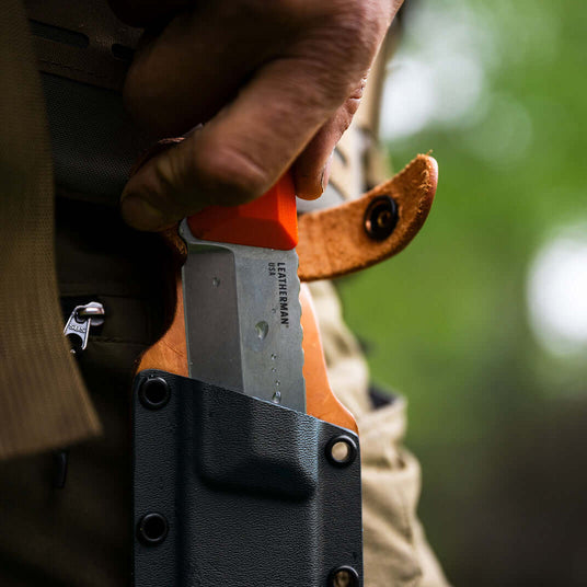 Translation missing: en.Close-up of an Orange Pop Leatherman Pioneer™ knife in a Kydex and Leather hybrid sheath, showcasing the G10 handle