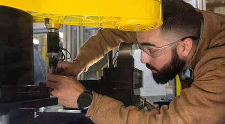 Translation missing: en.Edward Whidden-Rivera working with precision machinery in a workshop focused on engineering