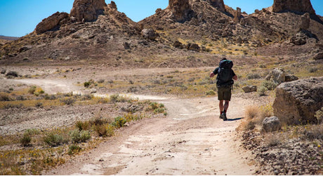 Translation missing: en.Hiker on a desert trail with hiking gear