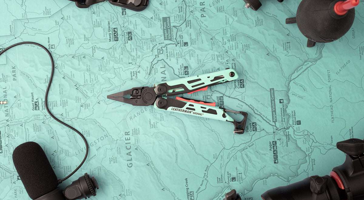 Aqua/Black Leatherman Signal® multi-tool displayed on a vintage map, showcasing its durable design and features.