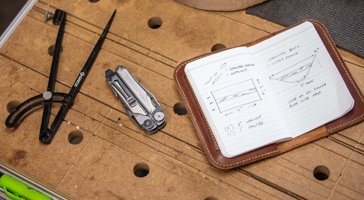 Image of tools including a compass, Stainless Steel Leatherman Wave® Plus with pocket clip, and a notebook for DIY projects.
