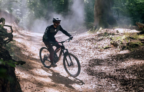 Translation missing: en.Cycling enthusiast navigating a forest trail with a mountain bike, showcasing the thrill of outdoor biking