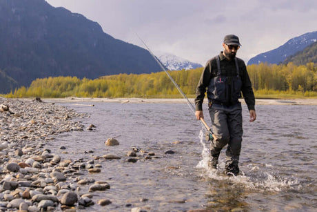 Translation missing: en.Man walking in a river wearing quality gear, showcasing readiness to go fishing