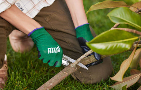 Translation missing: en.Person using a Stainless Steel Leatherman Rebar® multi-tool for gardening in a lush garden