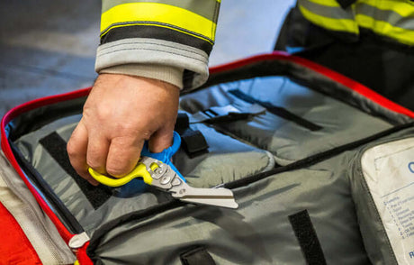 Translation missing: en.Hand holding Yellow/Blue Leatherman Raptor® Rescue multi-tool in a bag, perfect for emergency professionals