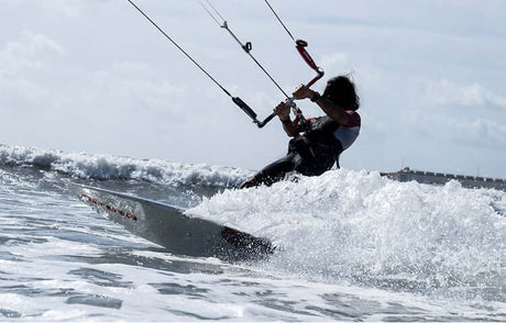 Translation missing: en.Kitesurfer riding waves, showcasing the thrill of Water Sports during a sunny day