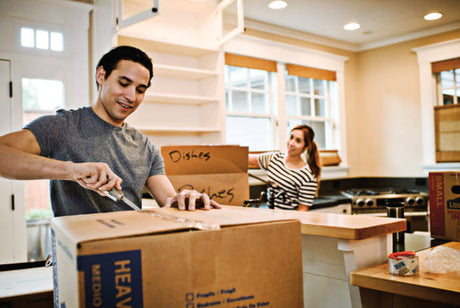 Translation missing: en.Two people unpacking boxes in a kitchen, utilizing a Leatherman multitool