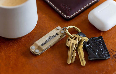Translation missing: en.Winter Fog Leatherman Micra® attached to keys next to a coffee cup, wallet and headphone case