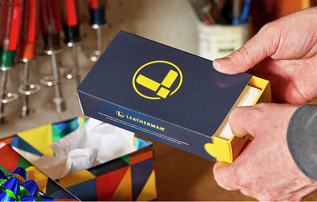 Translation missing: en.A man unwraps a present containing a Leatherman box