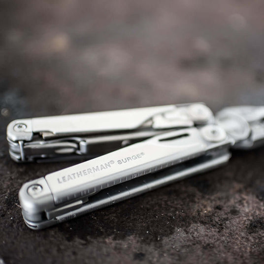 Translation missing: en.Close-up of a Stainless Steel Leatherman Surge® multitool on a dark surface, showcasing its sleek design