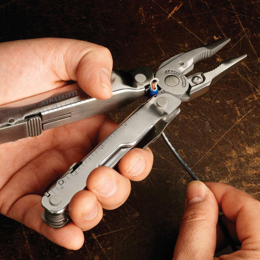 Translation missing: en.Person using a Stainless Steel Leatherman Super Tool® 300 multitool for electrical work