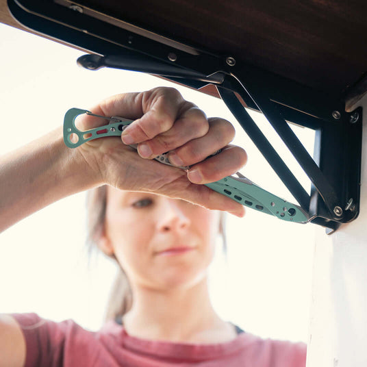 Translation missing: en.A woman using the Paradise Leatherman Skeletool® CX multi-tool to work on a project outdoors