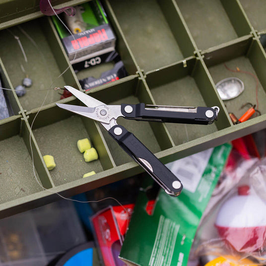 Translation missing: en.Jet Black Leatherman Micra® multi-tool featured in a cluttered toolbox with fishing supplies