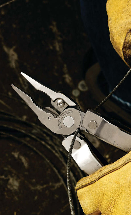 Translation missing: en.Close-up of a Stainless Steel Leatherman Super Tool® 300 in use, emphasizing the pliers gripping a wire, showcasing its functionality