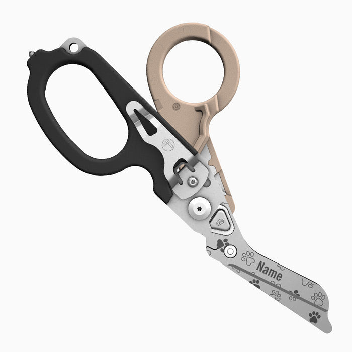 Translation missing: en.A two-tone tan-and-black-handled Leatherman Raptor Rescue tool with pawprints laser printed on the blade, which is personalized with the placeholder “Name.”
