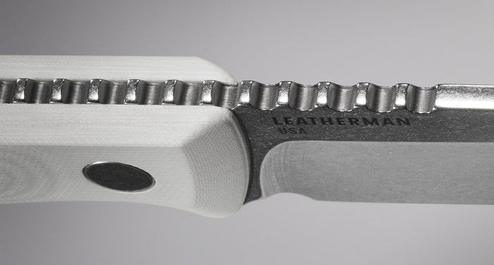 Translation missing: en.Close-up detail of a Leatherman knife showing the precision jimping along the spine of the blade, the textured white handle, and engraved "LEATHERMAN USA" branding, highlighting the knife's craftsmanship and grip-enhancing features