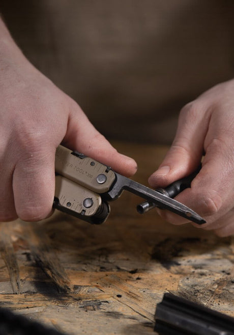 Translation missing: en.Close-up of hands holding a Coyote Tan Super Tool® 300 multitool for precision tasks
