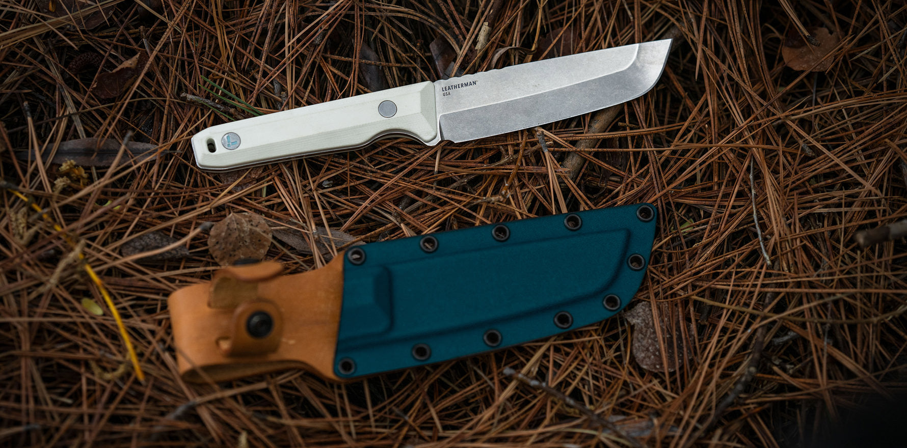 Alpine Leatherman Pioneer™ knife displayed on pine needles with its sheath in a natural outdoor setting.