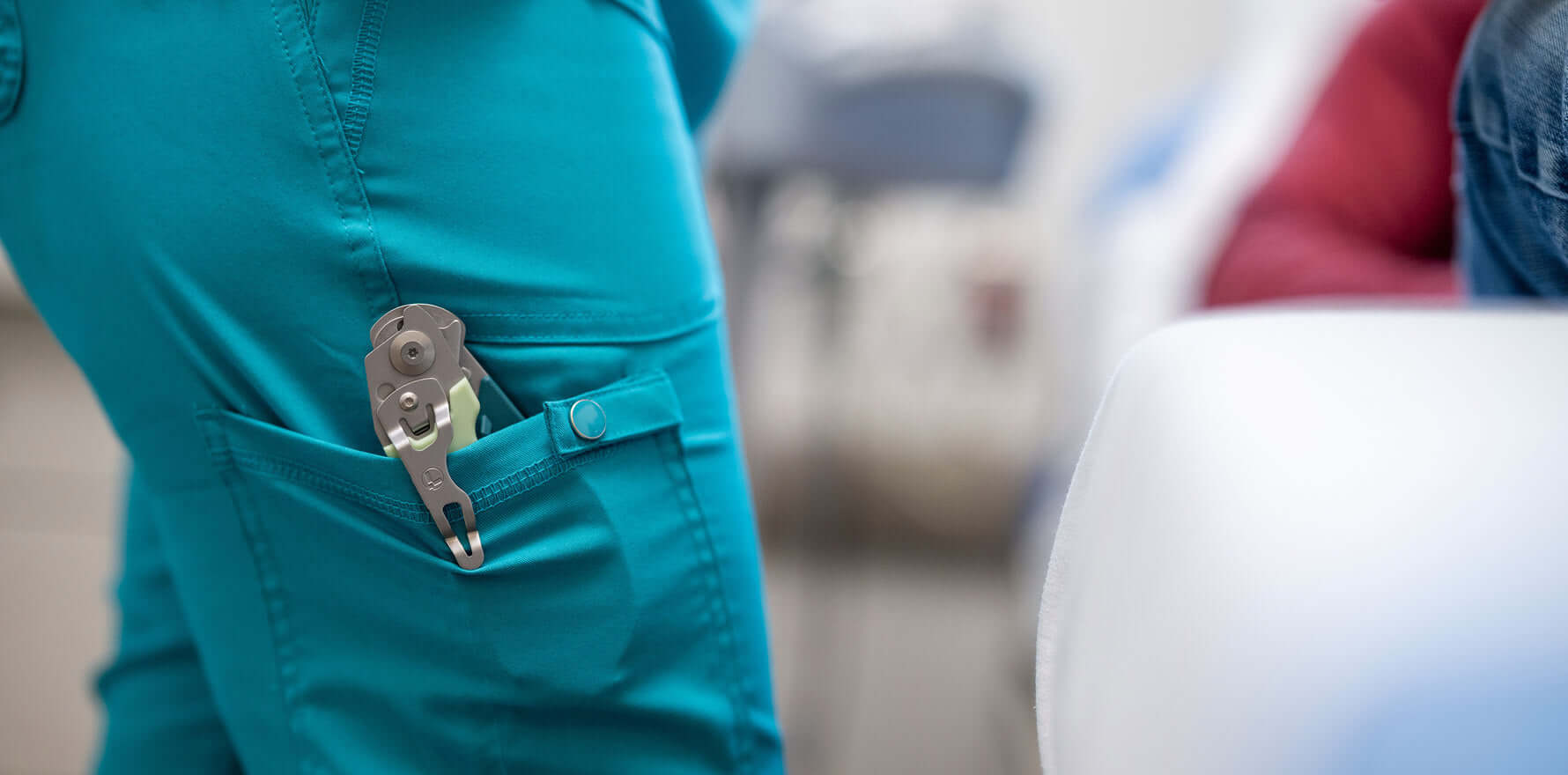 Medical personnel wearing scrubs with a pair of Icy Mint Leatherman Raptor® Rescue shears in their pocket.